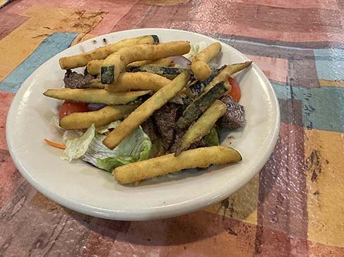 Ricardo’s Restaurant filet mignon steak salad lunch with perfectly grilled steak tips and French fries. 